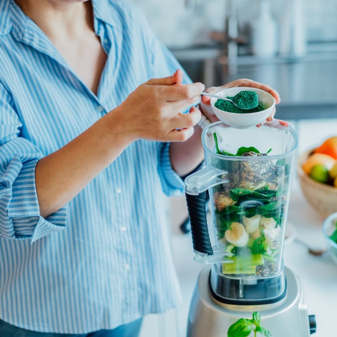 Frau bereitet einen Smoothie zu